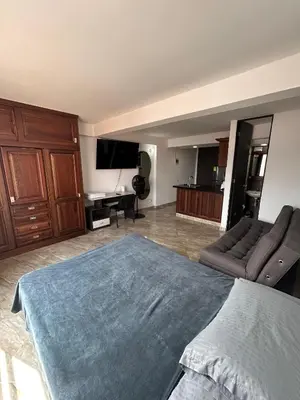 a bedroom with a large bed and a couch at Hermoso loft en medellin in Medellín