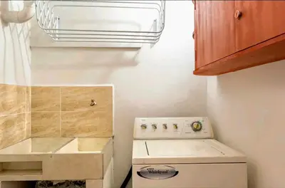 a washer and dryer in a small kitchen at Hermosa Habitación in Medellín