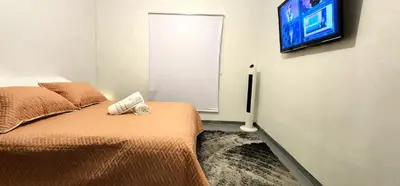 a bedroom with a bed and a flat screen tv at Hermosa Habitación in Medellín