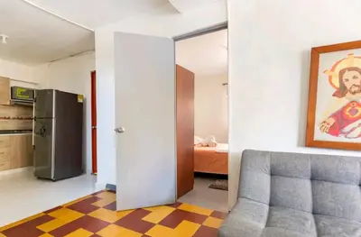 a room with a door and a kitchen with a refrigerator at Hermosa Habitación in Medellín
