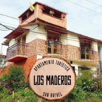 a building with a sign in front of it at Los Maderos San Rafael Antioquia Apartamento Turístico in San Rafael