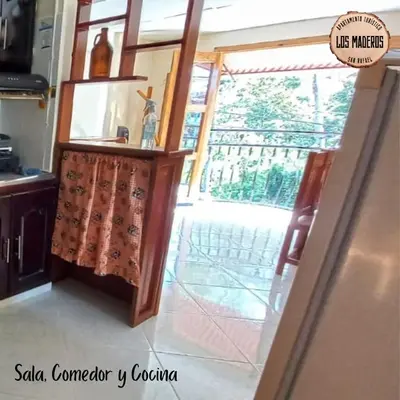 a kitchen with a table with a curtain on it at Los Maderos San Rafael Antioquia Apartamento Turístico in San Rafael