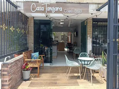 a cafe with chairs and a table on a patio at Casa Tangara Café y Hospedaje in Medellín