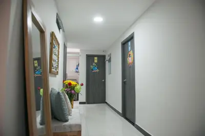 a hallway with a black door and a vase of flowers at Casa Tangara Café y Hospedaje in Medellín