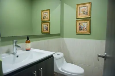 a bathroom with a sink and a toilet and a mirror at Casa Tangara Café y Hospedaje in Medellín