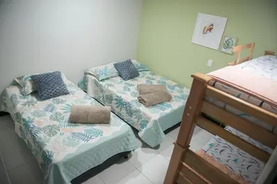 a room with two beds and a bunk bed at Casa Tangara Café y Hospedaje in Medellín