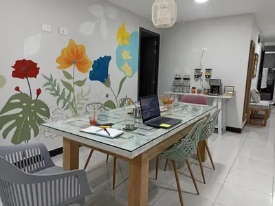 a dining room with a table with a laptop on it at Casa Tangara Café y Hospedaje in Medellín