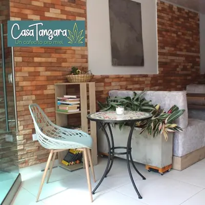 a table and two chairs sitting next to a couch at Casa Tangara Café y Hospedaje in Medellín