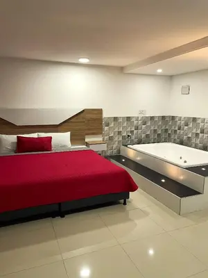 a bedroom with a bed and a bath tub at Hotel Ofix in Medellín