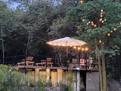 a deck with an umbrella and tables and chairs at Tuku, in Guarinocito