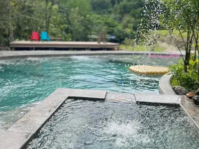 a swimming pool with a fountain in the middle at Tuku, in Guarinocito