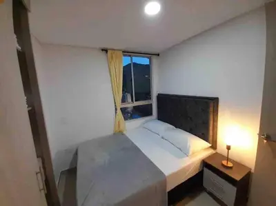a bedroom with a large bed and a window at Piso26 Beautifull Apartment and Parking in Sabaneta