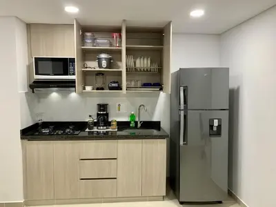 a kitchen with a stainless steel refrigerator and cabinets at Piso26 Beautifull Apartment and Parking in Sabaneta