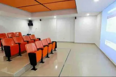 an empty room with orange chairs and a projection screen at Piso26 Beautifull Apartment and Parking in Sabaneta