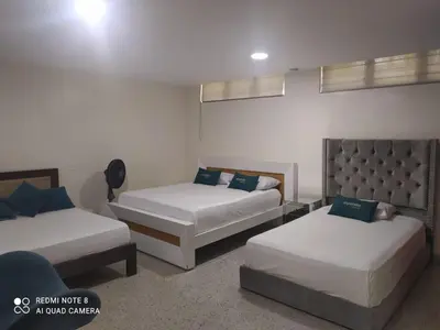 a bedroom with two beds and a couch at Hotel Villa Park Real in Medellín