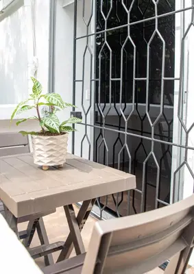 a table and a chair and a plant on a porch at Hotel Villa Park Real in Medellín