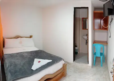 a bedroom with a bed and a door to a bathroom at Hotel la Victoria in San Roque