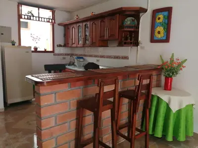 a kitchen with a brick bar with stools at Las Orquídeas Jardín Casa Hotel in Jardin
