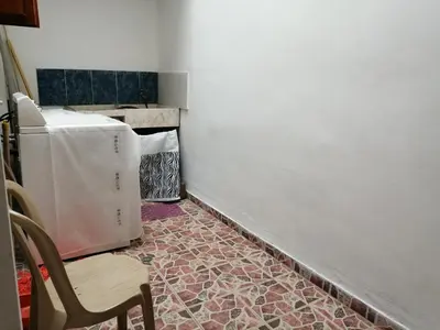 a room with a refrigerator and a table and a chair at Las Orquídeas Jardín Casa Hotel in Jardin