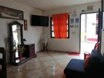 a living room with a mirror and a tv at Las Orquídeas Jardín Casa Hotel in Jardin