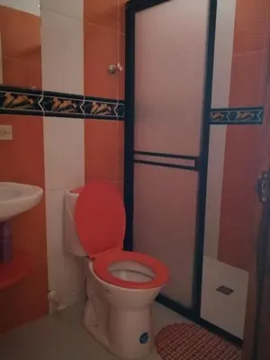 a bathroom with a toilet with a red lid at Las Orquídeas Jardín Casa Hotel in Jardin