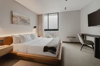 a bedroom with a bed and a desk and a computer at Seissta Medellín in Medellín