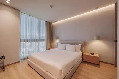 a bedroom with a large bed and a large window at Seissta Medellín in Medellín