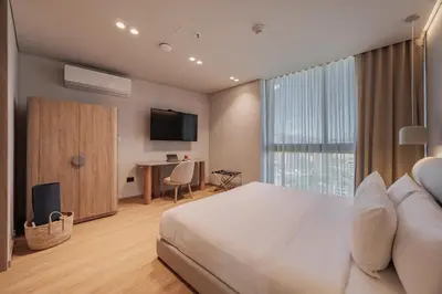 a bedroom with a bed and a desk and a television at Seissta Medellín in Medellín