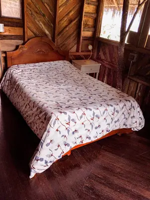 a bedroom with a bed in a wooden cabin at hospedaje rural finca cafetera La Maloka in Jardin