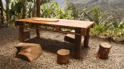 a wooden table sitting on top of some logs at hospedaje rural finca cafetera La Maloka in Jardin