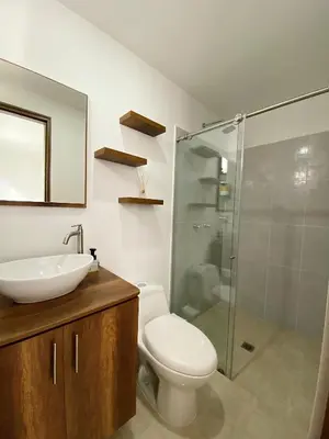 a bathroom with a toilet and a sink and a shower at Jardín de Primavera Apartamentos in Jardin