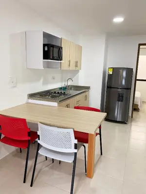 a kitchen with a wooden table and red chairs at Jardín de Primavera Apartamentos in Jardin