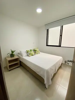 a white bedroom with a bed and a window at Jardín de Primavera Apartamentos in Jardin