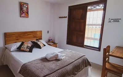 a bedroom with a bed and a window at Famy Hostal Nardo's in Jardin