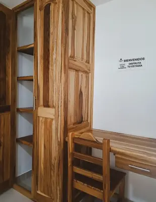 a wooden bookcase next to a wooden desk at Famy Hostal Nardo's in Jardin