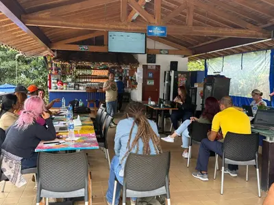 a group of people sitting at tables in a restaurant at Pura vida alojamiento in Barbosa