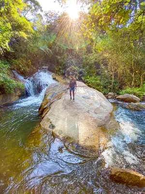 a man walking on a rock in a river at Pura vida alojamiento in Barbosa