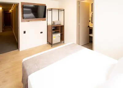 a bedroom with a bed and a flat screen tv at Fence by Bernalo Hotels in Medellín