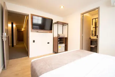 a bedroom with a bed and a flat screen tv at Fence by Bernalo Hotels in Medellín