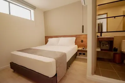 a bedroom with a white bed and a window at Fence by Bernalo Hotels in Medellín