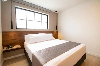 a bedroom with a large bed with a window at Fence by Bernalo Hotels in Medellín