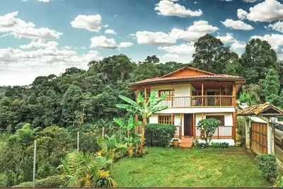 a house in the middle of a field with trees at Mirador de los Vientos in Manizales