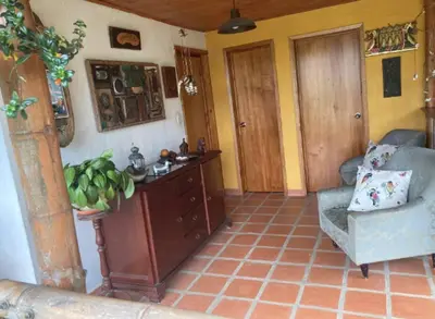 a living room with a couch and a table and a chair at Mirador de los Vientos in Manizales