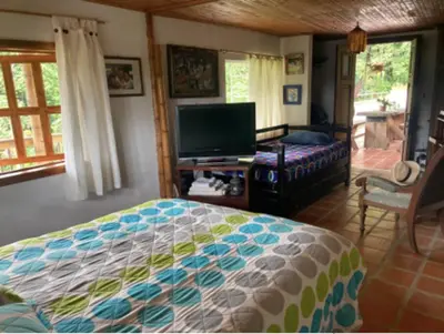 a bedroom with a bed and a flat screen tv at Mirador de los Vientos in Manizales