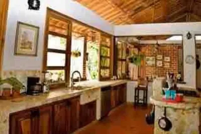 a large kitchen with a sink and a counter at Finca La Estación en Santa Fe de Antioquia in Santa Fe de Antioquia