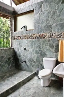 a stone bathroom with a toilet and a sink at Finca La Estación en Santa Fe de Antioquia in Santa Fe de Antioquia