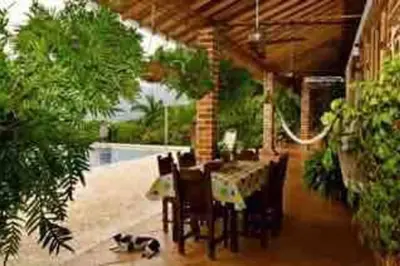 a dining room with a table and chairs and a table and chairsktop at Finca La Estación en Santa Fe de Antioquia in Santa Fe de Antioquia