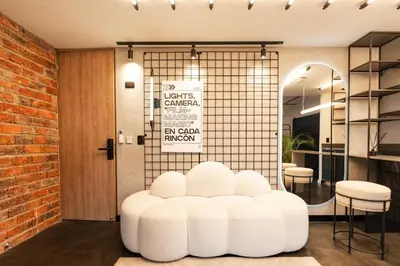 a room with a white stool in front of a door at Indie Universe Creative Hotel in Medellín
