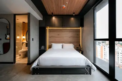 a bedroom with a large bed and a large window at Indie Universe Creative Hotel in Medellín