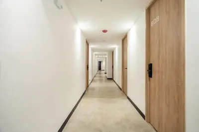 a hallway with white walls and wooden doors at Indie Universe Creative Hotel in Medellín